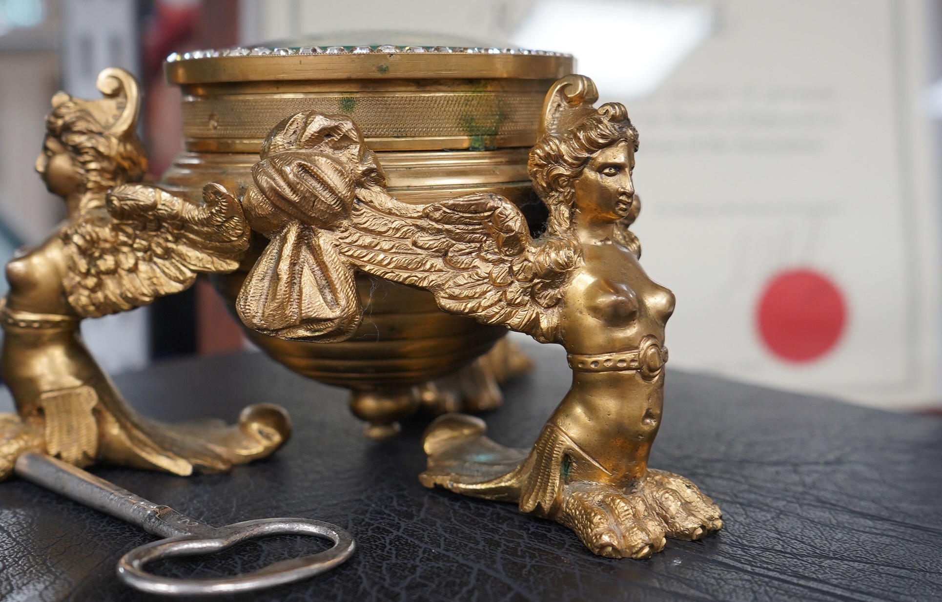 A 19th century French ormolu table timepiece decorated with paste jewelling edged dial and three classical figures, widest point 15cm. Condition - good, not been checked as working